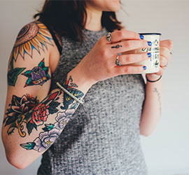 Person holding a tan leather briefcase while working on a laptop