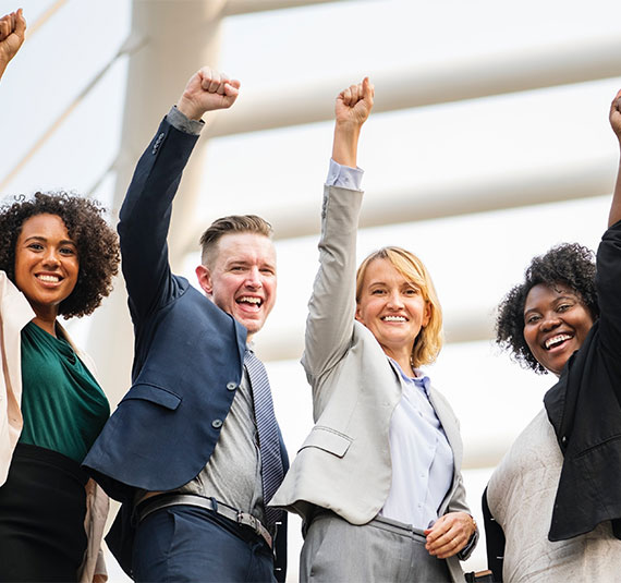Group of colleagues celebrating with arms raised