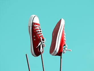 Red canvas trainers against a turquoise background