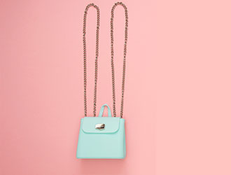 Small light blue shoulder bag on a pink background