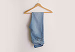 Light blue jeans hanging on a wooden hanger
