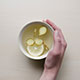 Hand holding a cup of lemon water