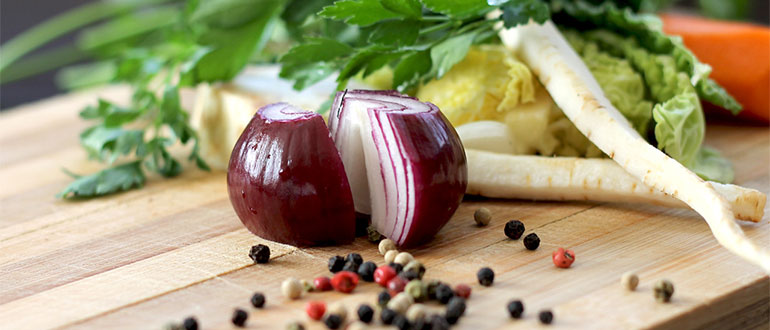 Red onion and vegetables on a chopping board