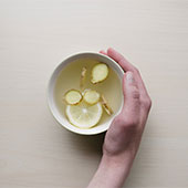 Hand holding a cup of lemon water
