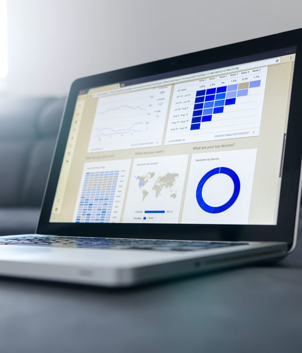 Laptop displaying web analytics dashboards with charts, graphs, and a world map, representing website performance monitoring.
