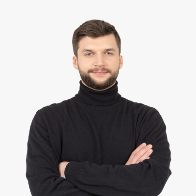 Studio portrait of a man with a beard wearing a black turtleneck, standing with arms crossed against a white background.