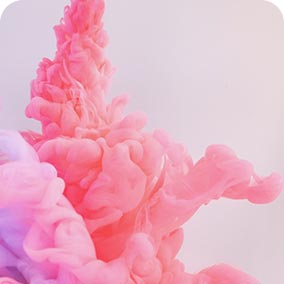 Abstract swirling pink ink in water creating soft, flowing shapes against a light background.