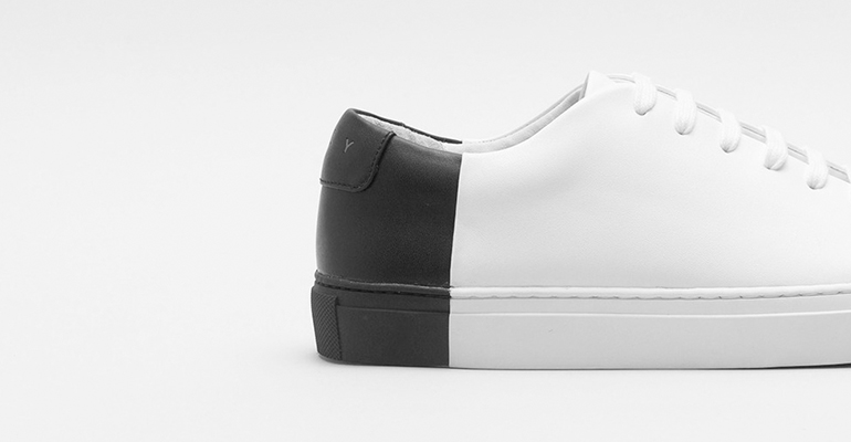 Close-up of a white and black leather sneaker on a plain background