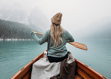 Rear image of woman paddling boat