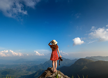 Image of woman with camera on mountain top