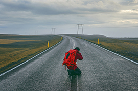 Image of man taking photo in middle of highway