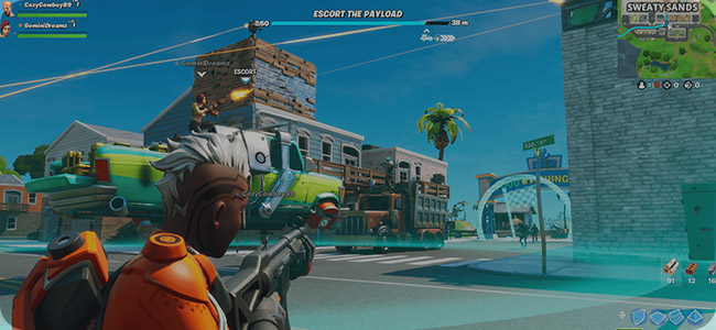 Characters engaging in a Fortnite game mode, escorting a payload through an urban environment with weapons drawn.